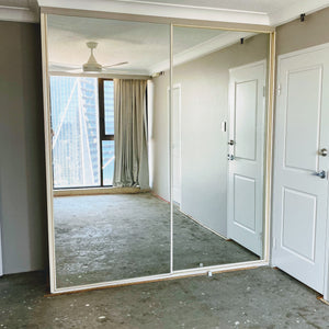 White framed, mirror inserts wardrobe sliding doors.